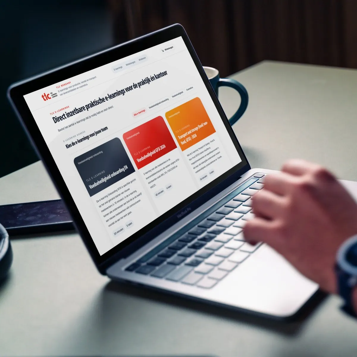 Iemand werkt op een laptop met de webshop van The Learning Company op het scherm: e-learnings voor voedselveiligheid, te bestellen per team